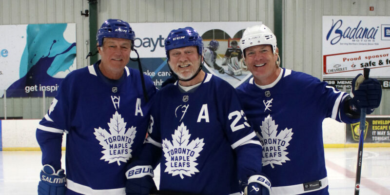 Three LAefs players pose in Leafs jerseys.